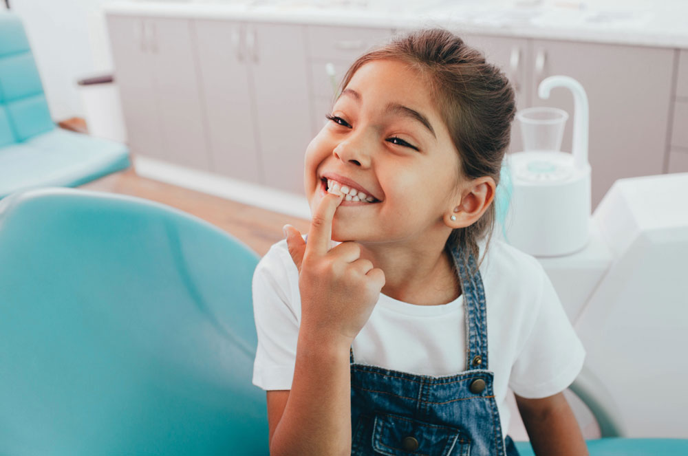 Ett barn hos tandläkaren som visar sina tänder